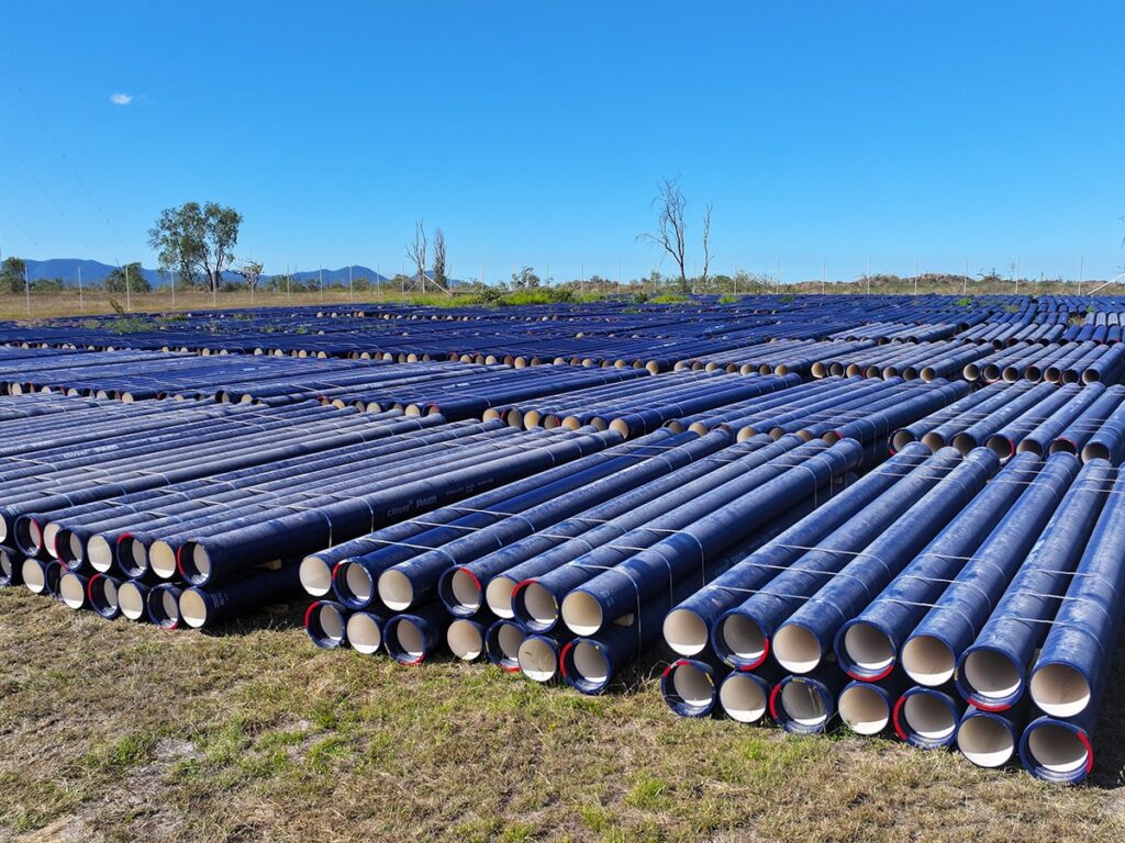 Stacked ductile iron pipe on site.