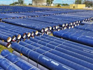 Large number of ductile iron pipes stacked on site.