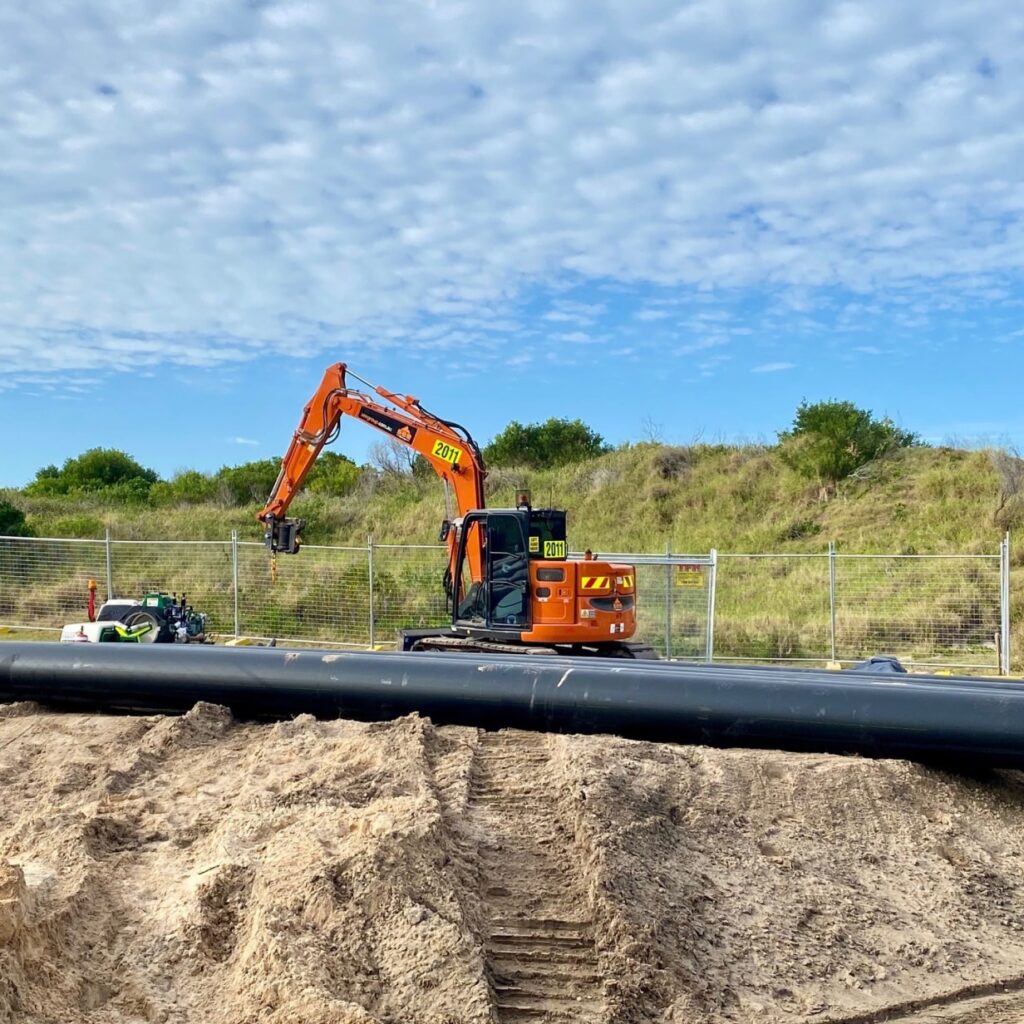 excavator next to large polyethylene pipe