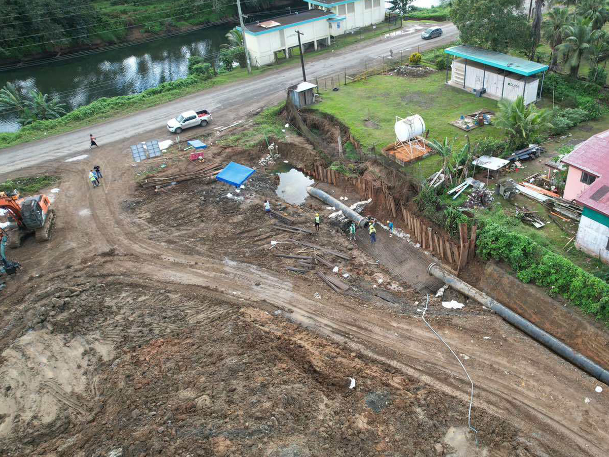 Overhead perspective of a construction site showcasing a house and an adjacent road in development.